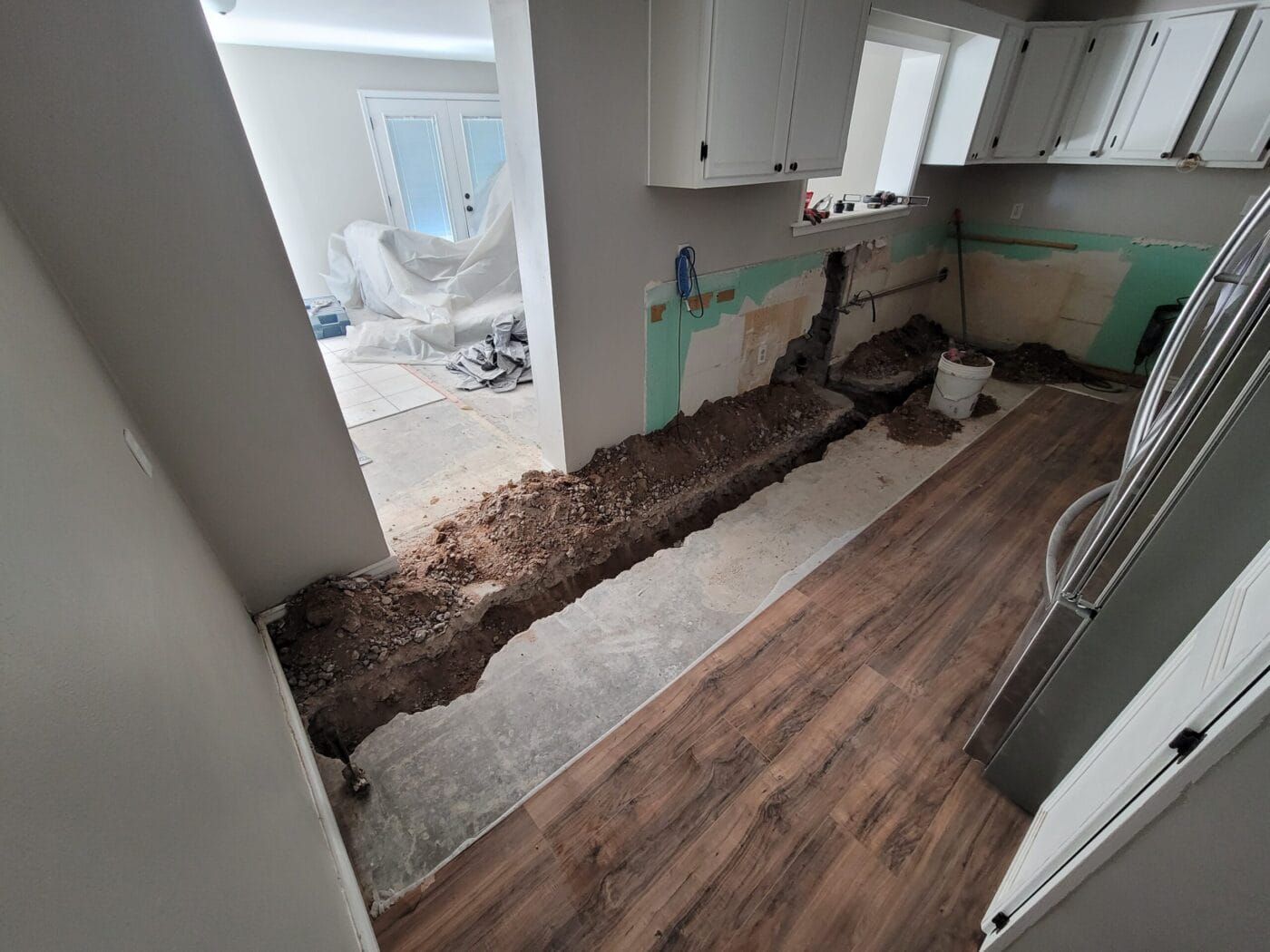 A kitchen under construction with a hole in the floor.