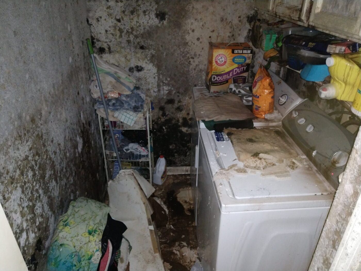 A dirty laundry room with a washer and dryer.