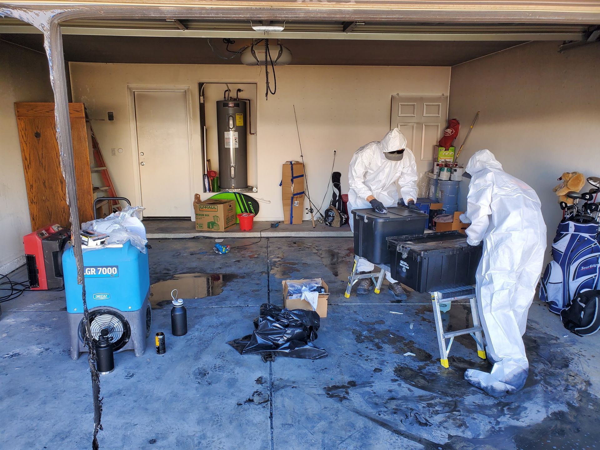 A group of people in protective suits are working in a garage.