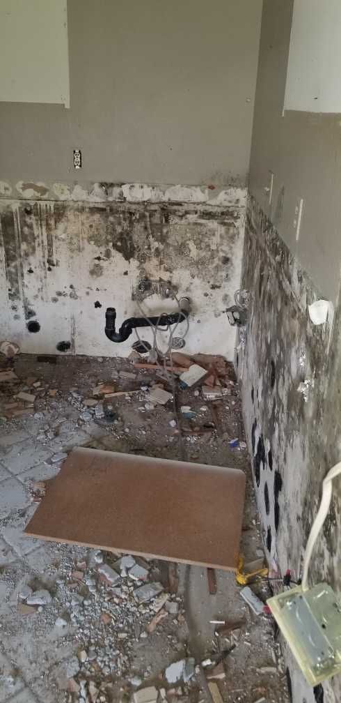 A bathroom under construction with a sink and a tile floor.