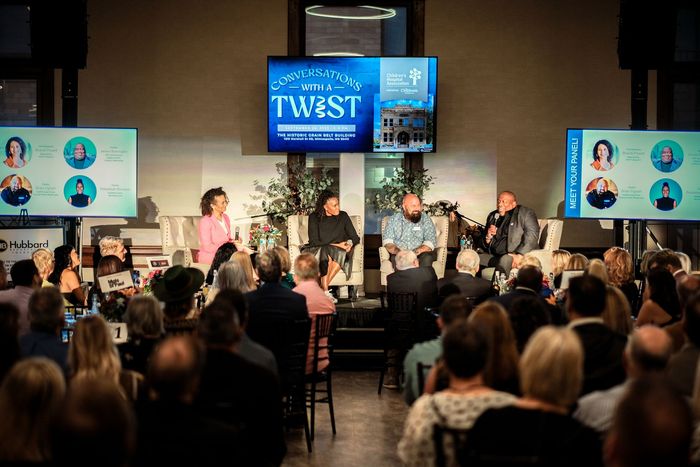 A panel of speakers talks to guests at the premier event
