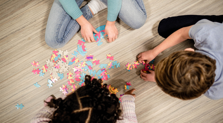 Three pediatric patients work together to put together a puzzle 