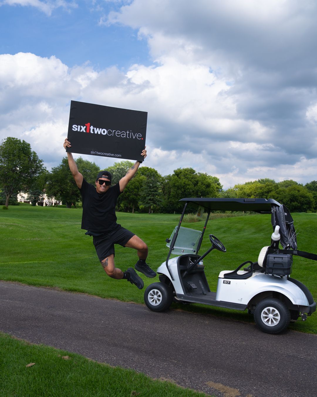 Six1two staffer holding up a sign with their logo while clicking his heals midair.