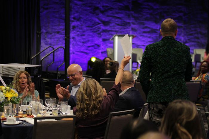 A guest raises their bid card high at a fundraising event