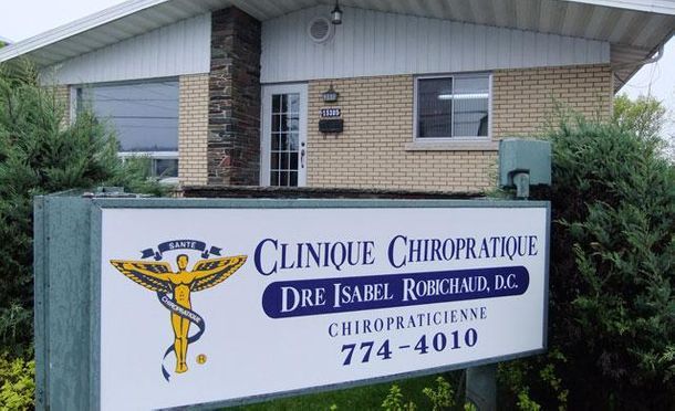 Un panneau de clinique chiropratique devant un bâtiment en brique