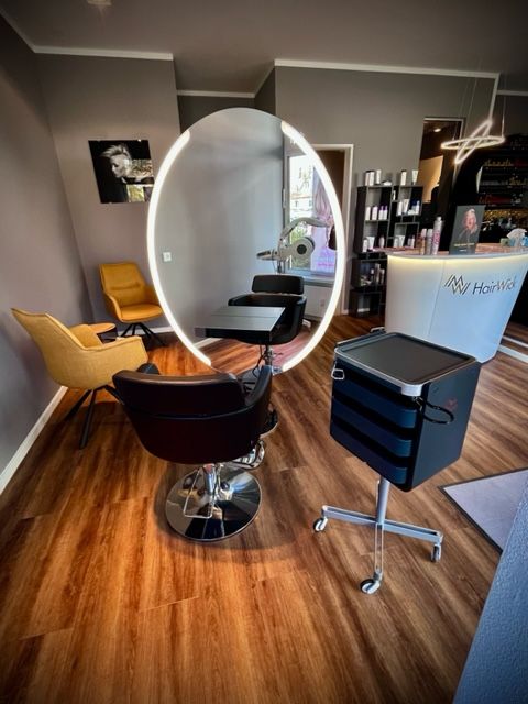 Ein Friseursalon mit großem Spiegel und Stühlen