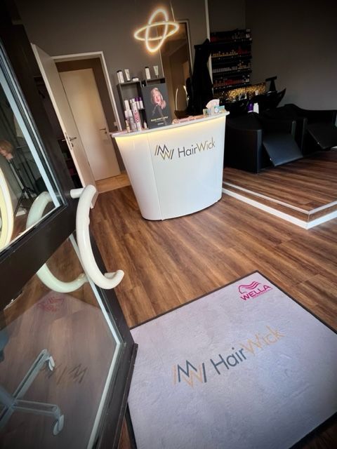 Ein Friseursalon mit einer weißen Theke und einem Teppich