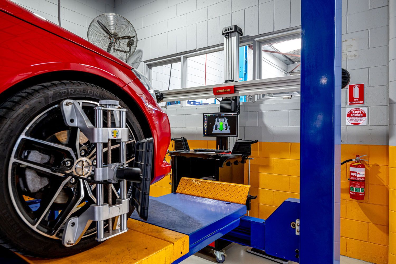 A Red Car Is Being Adjusted By A Machine In A Garage - Prospect, SA - Topgear Automotive Services