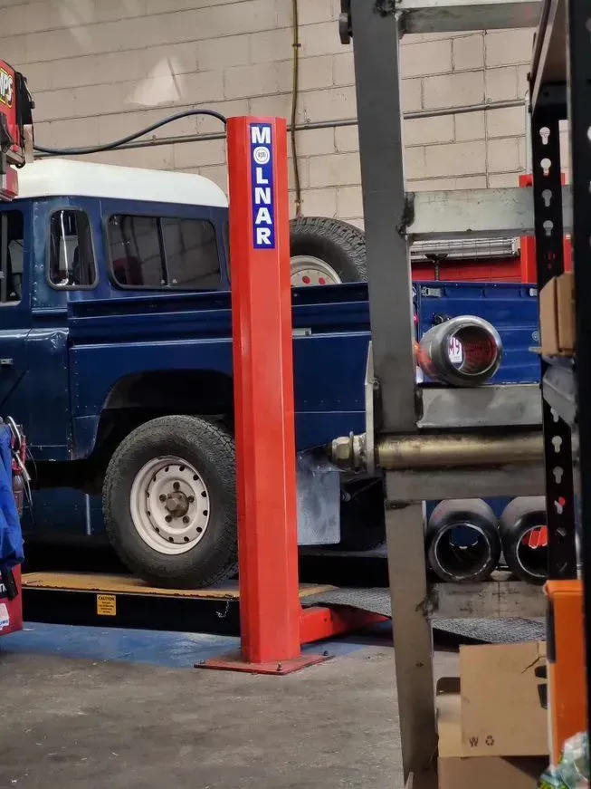 Red Molnar Car Lift — BJM Mechanical Mufflers & Tyres in Oxenford, QLD