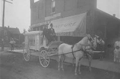 Black and white photo of carriage with horses