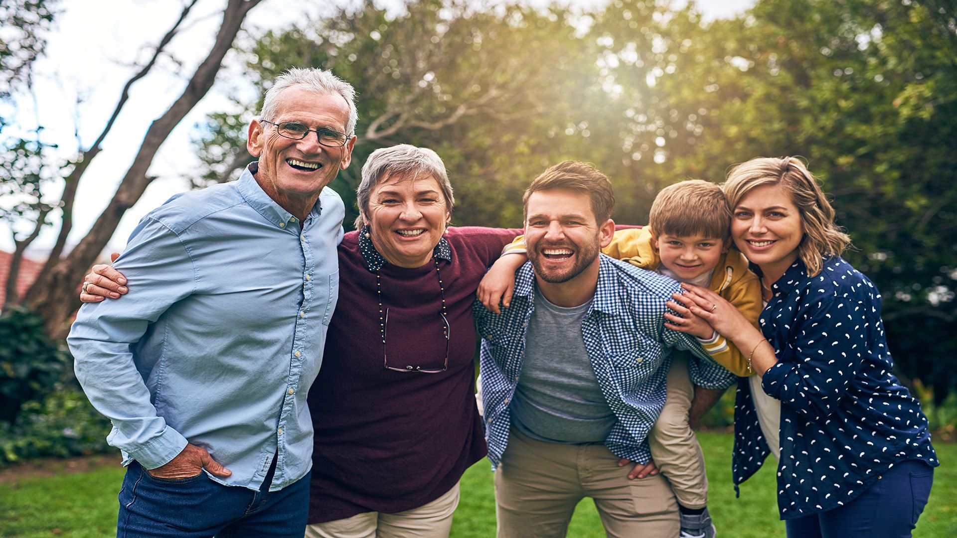 A family is posing for a picture together in a park.