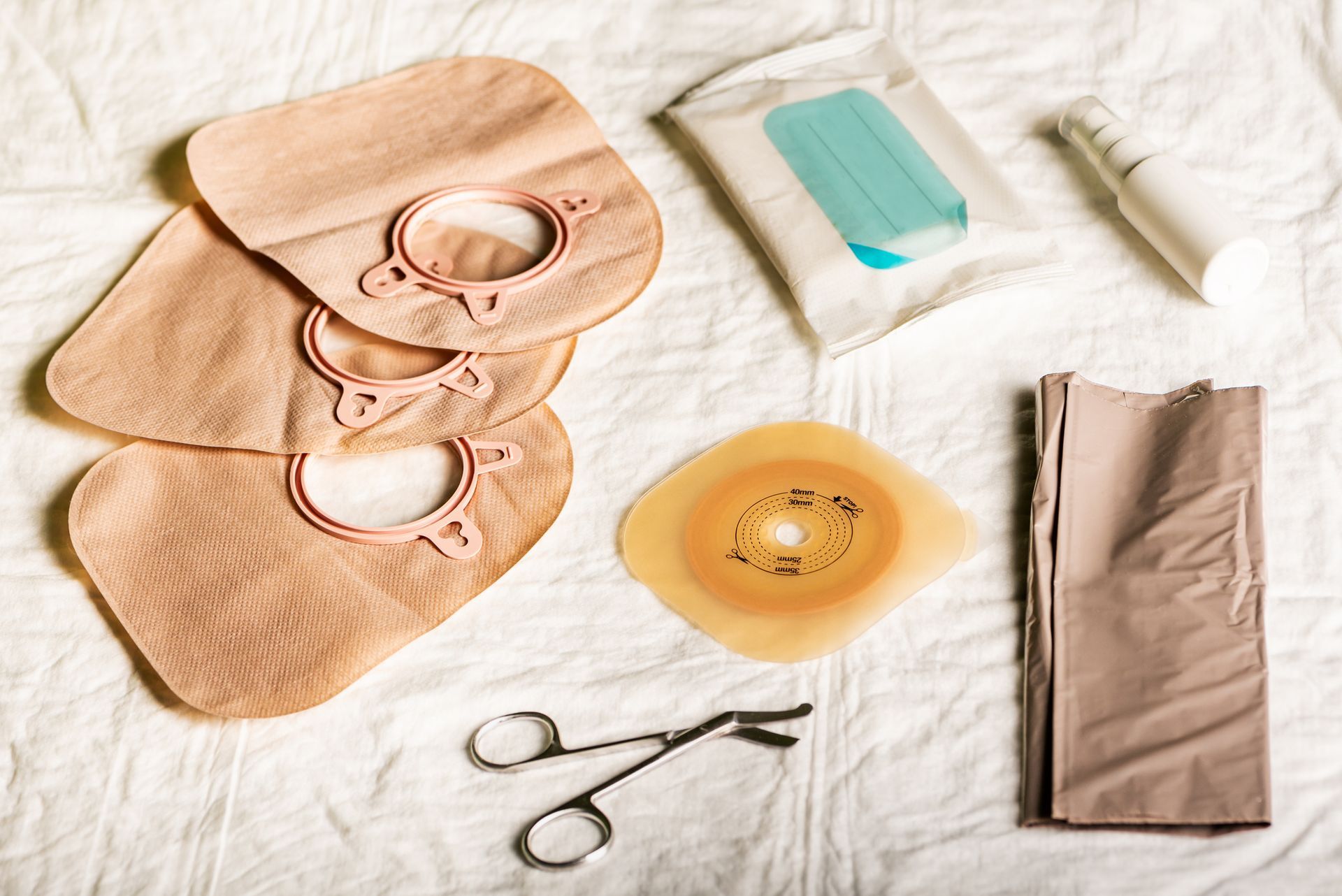 There are many different types of stoma bags on the bed.