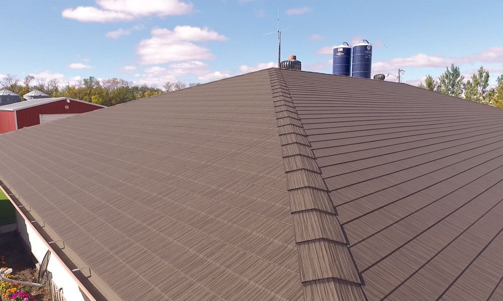 An aerial view of a roof of a house with silos in the background.