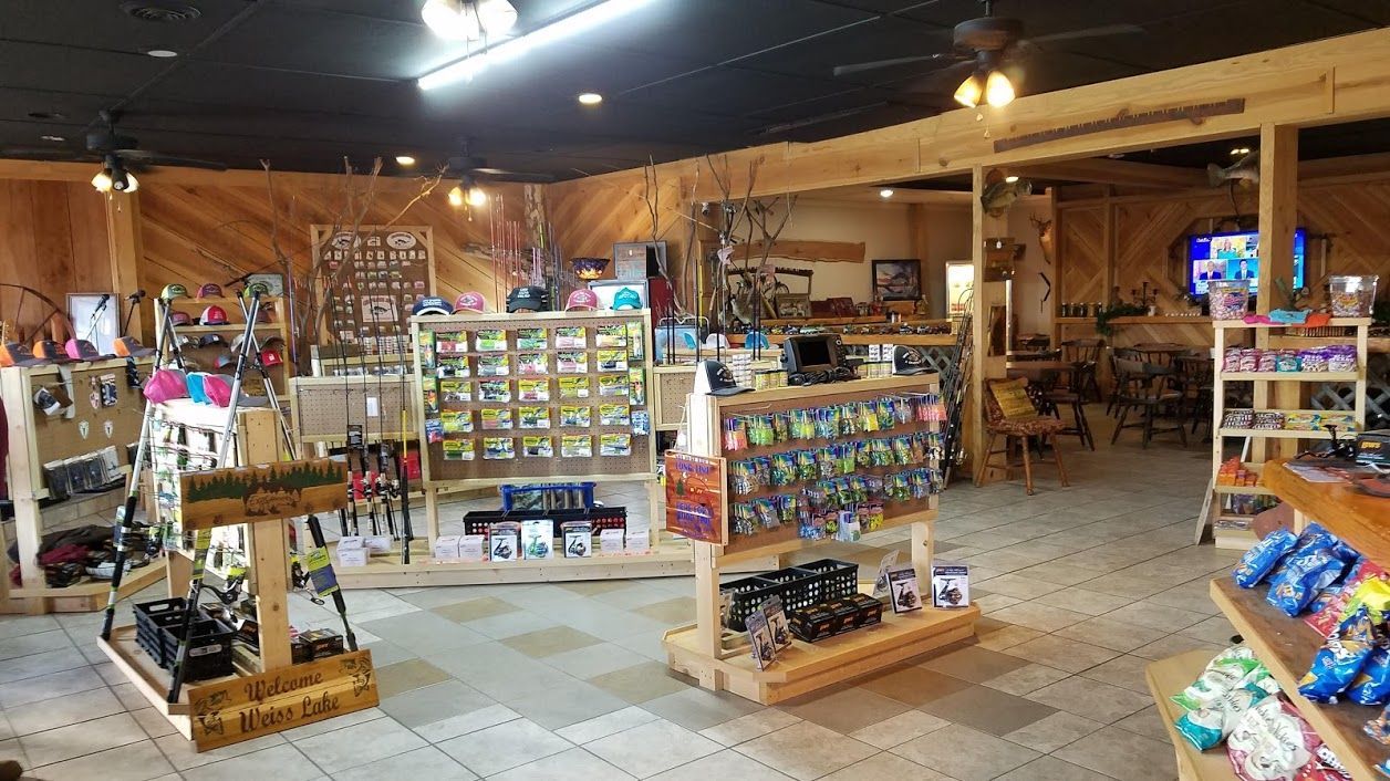 A retail store featuring archery equipment, including bows on display racks and various small accessories on shelves.