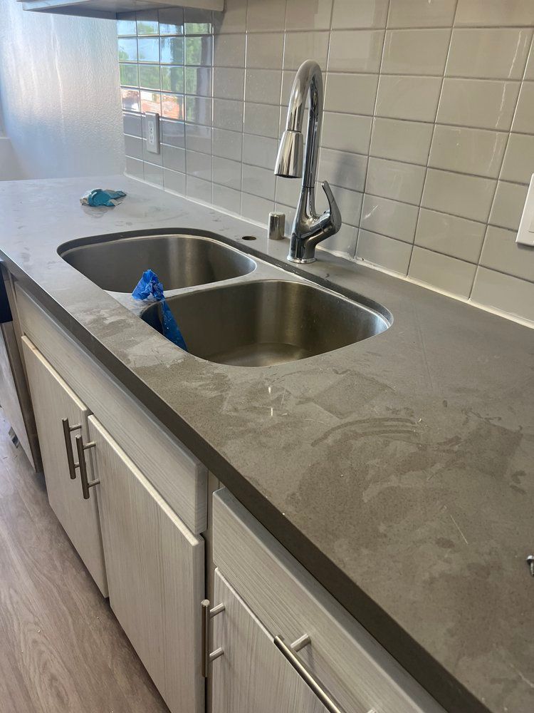 A kitchen with two sinks and a faucet.
