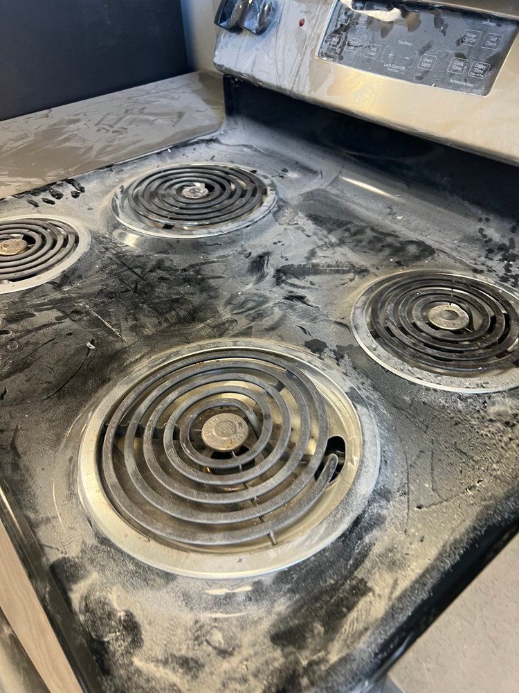 A close up of a dirty stove top oven.
