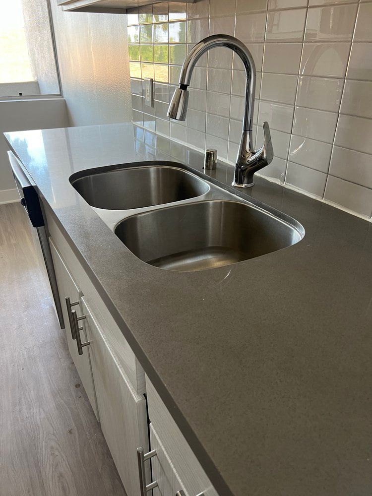 A kitchen with two sinks and a faucet on the counter.