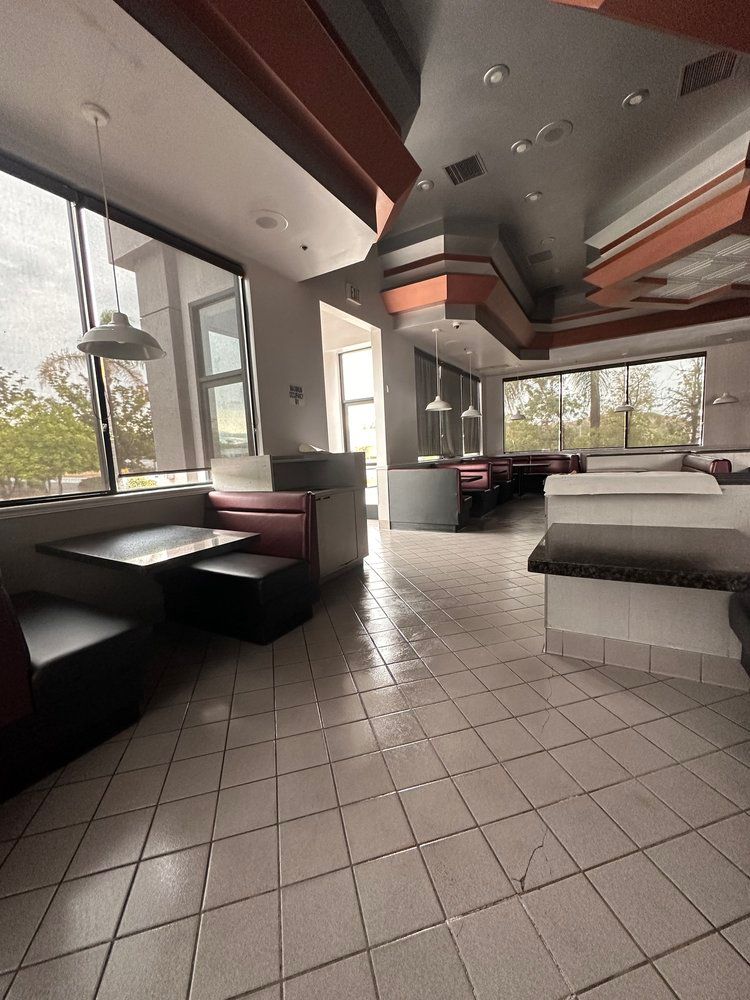 A restaurant with tables and chairs and a tiled floor.