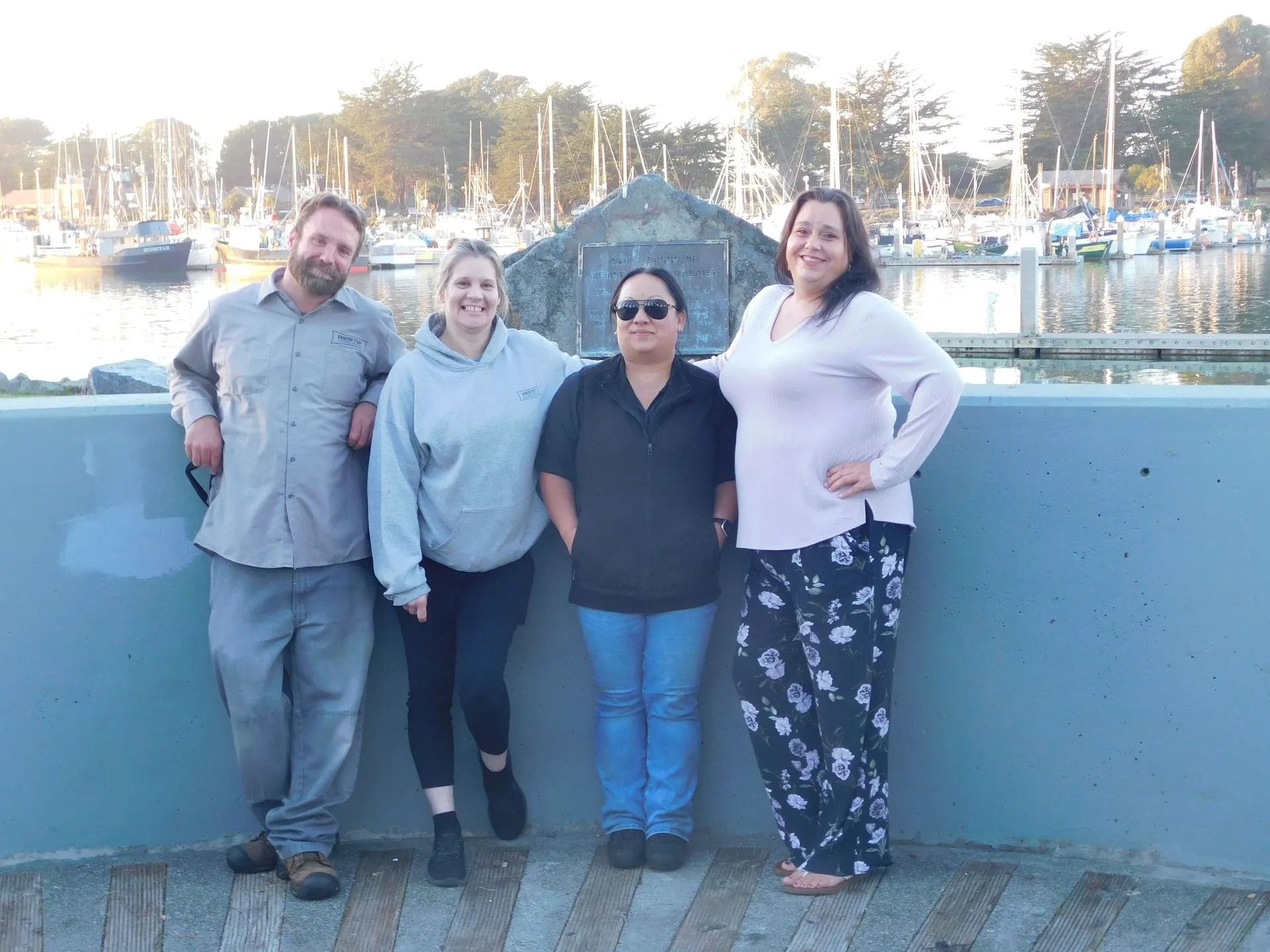 A group of people are posing for a picture in front of a harbor