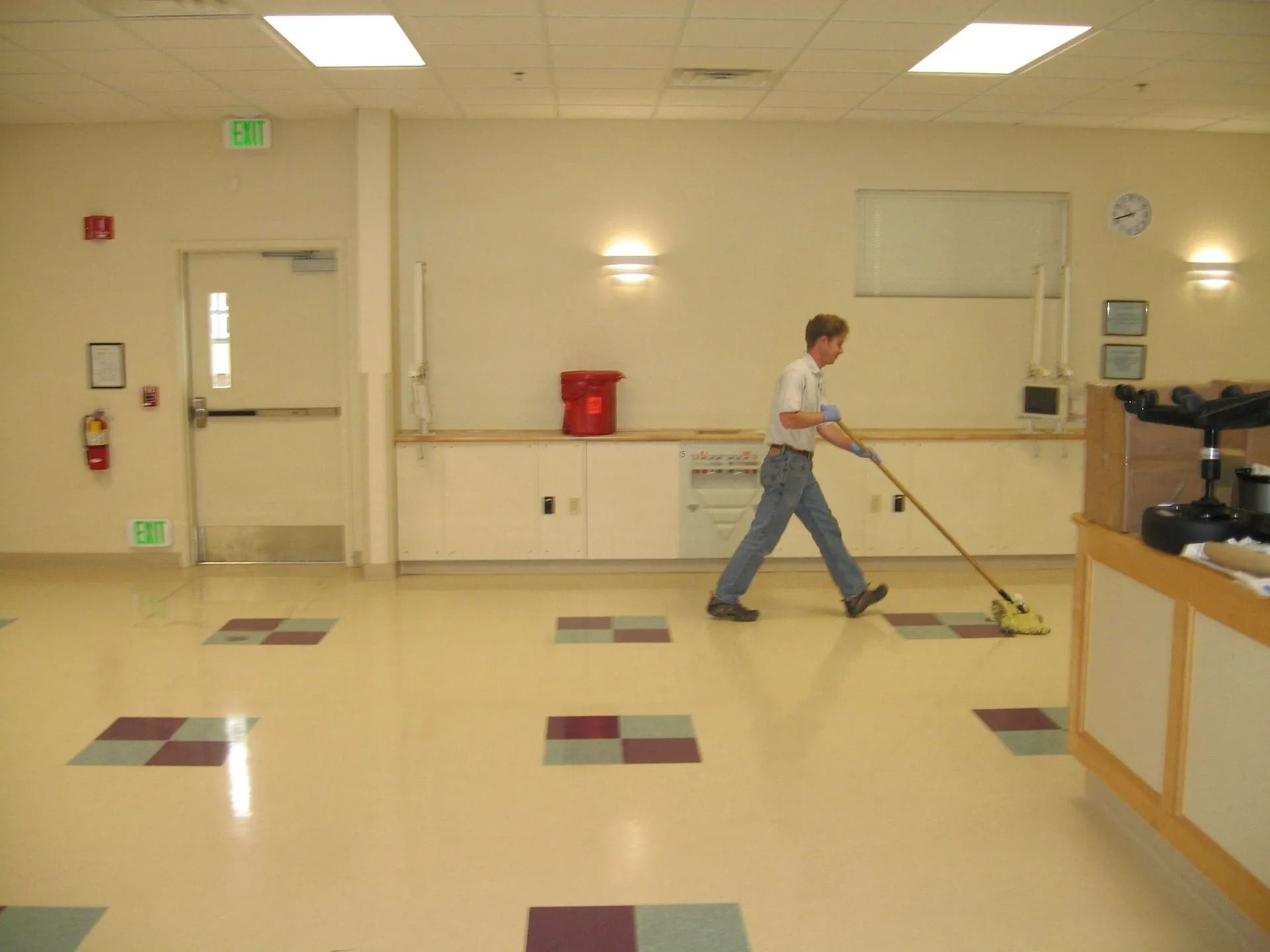 A man cleaning a floor with a mop and bucket