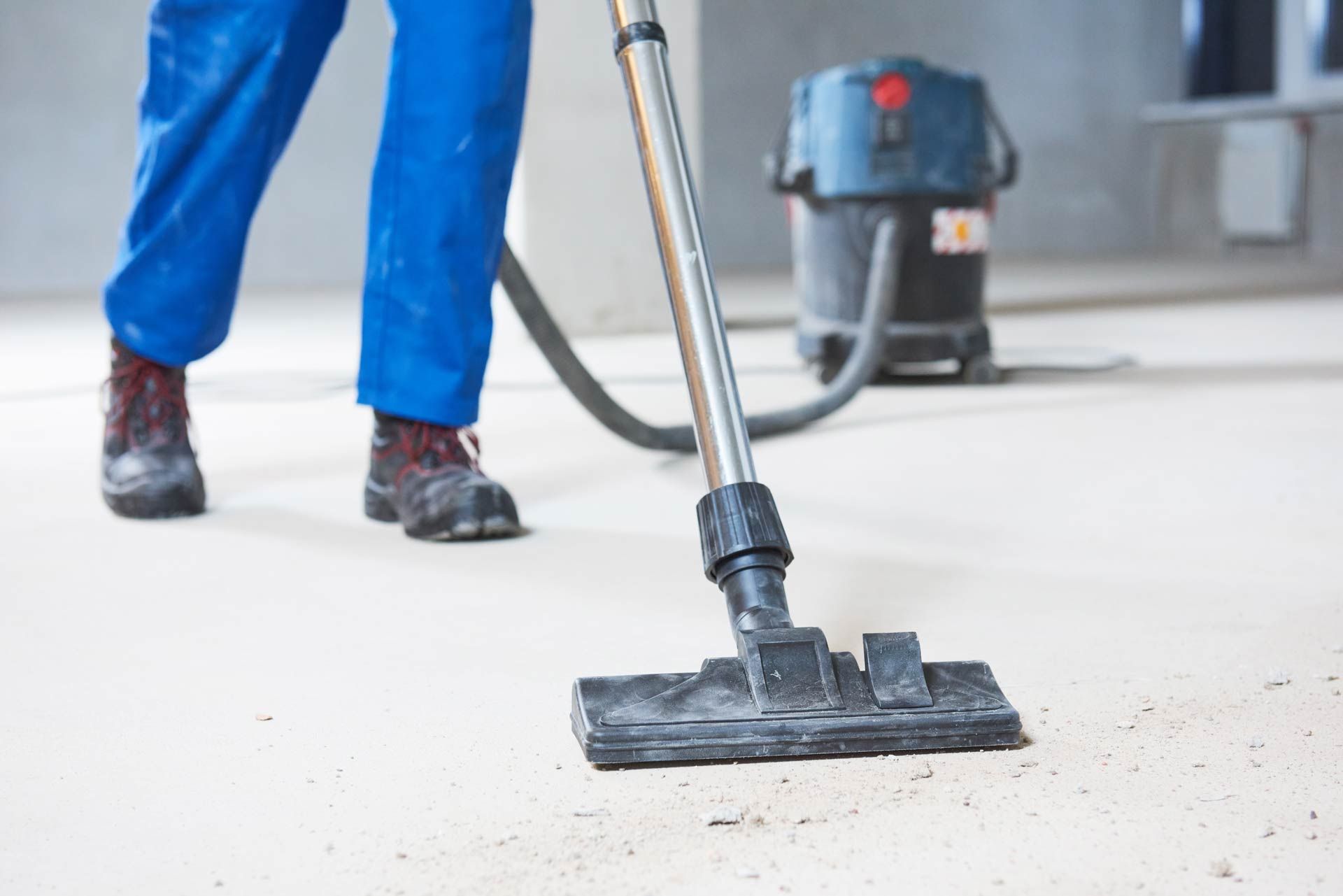 A man is using a vacuum cleaner to clean the floor