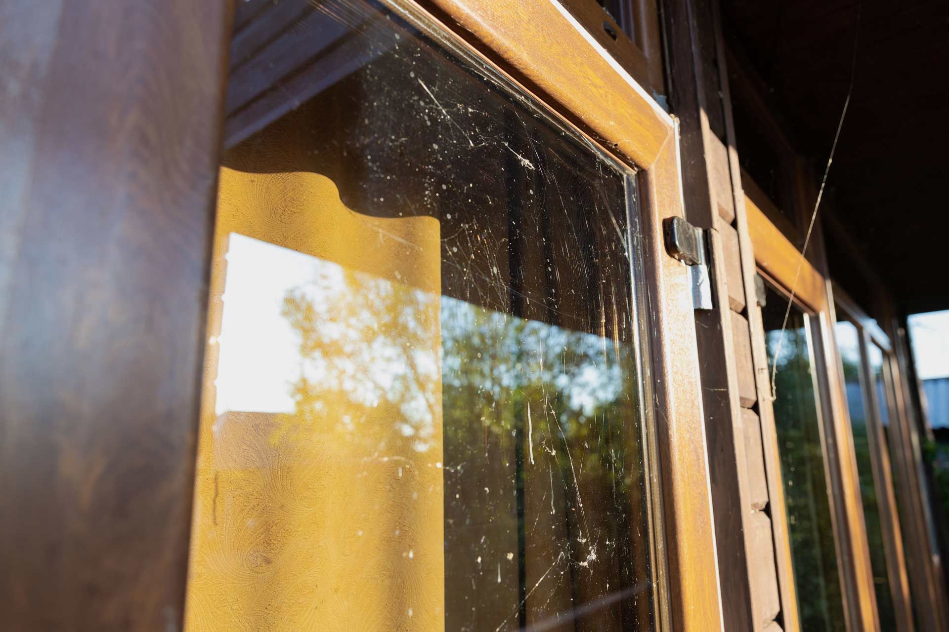 A close up of a window with a spider web on it.