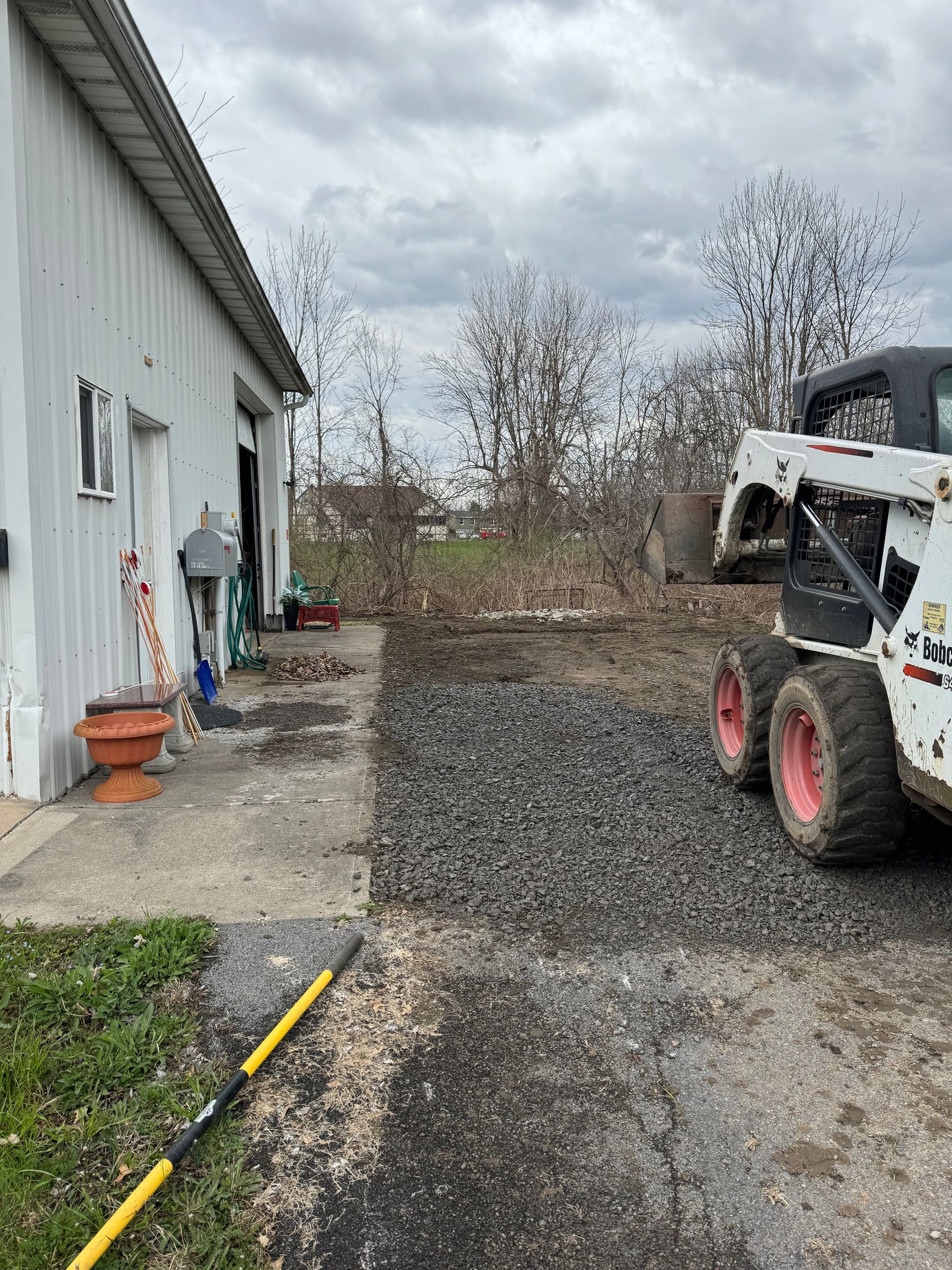 A bobcat is parked in front of a building.