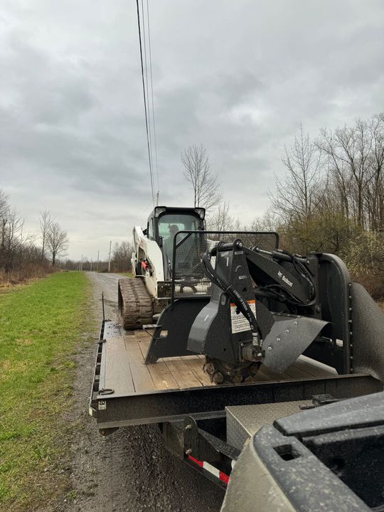 A bulldozer is sitting on top of a trailer next to a truck.
