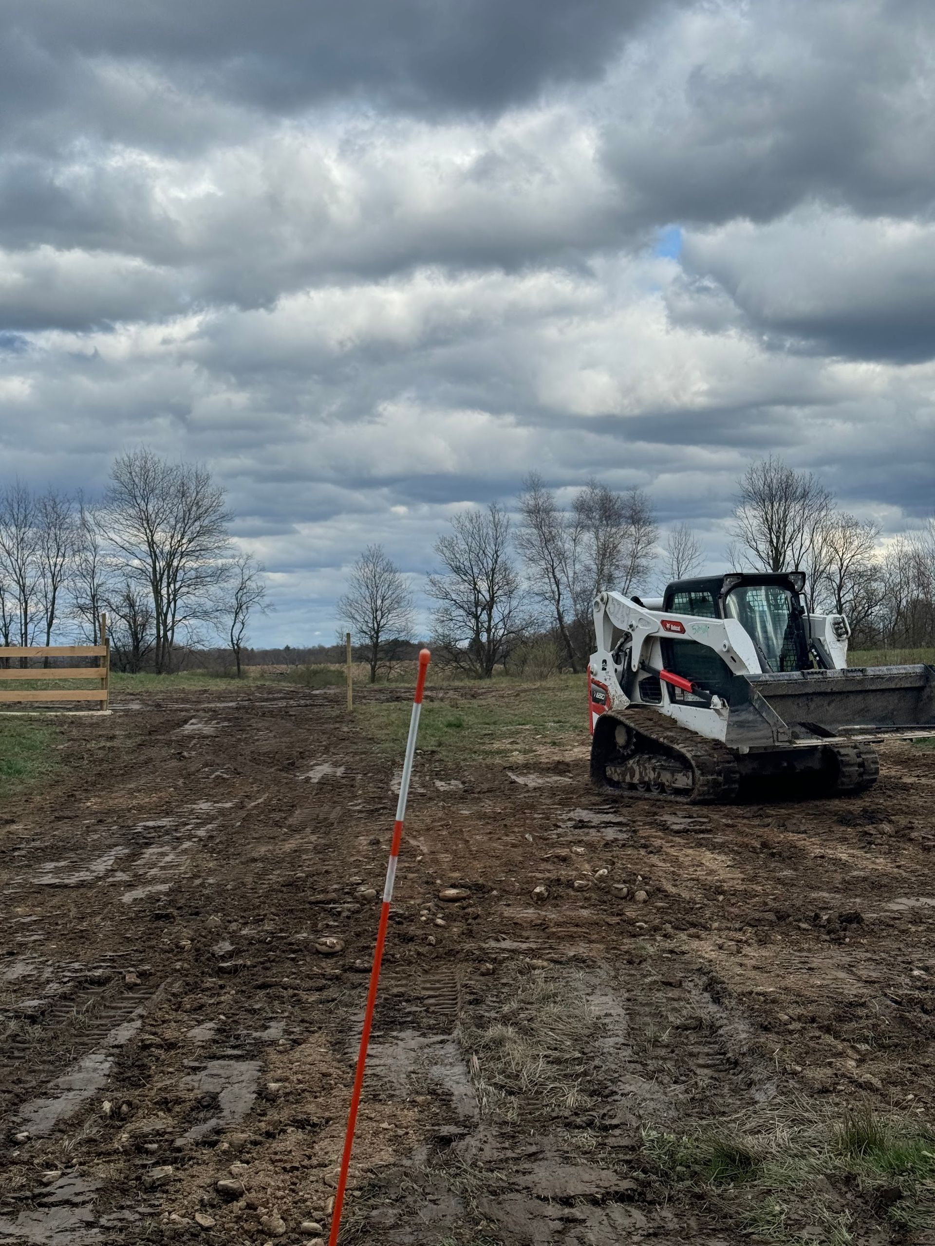 A bulldozer is driving through a muddy field.