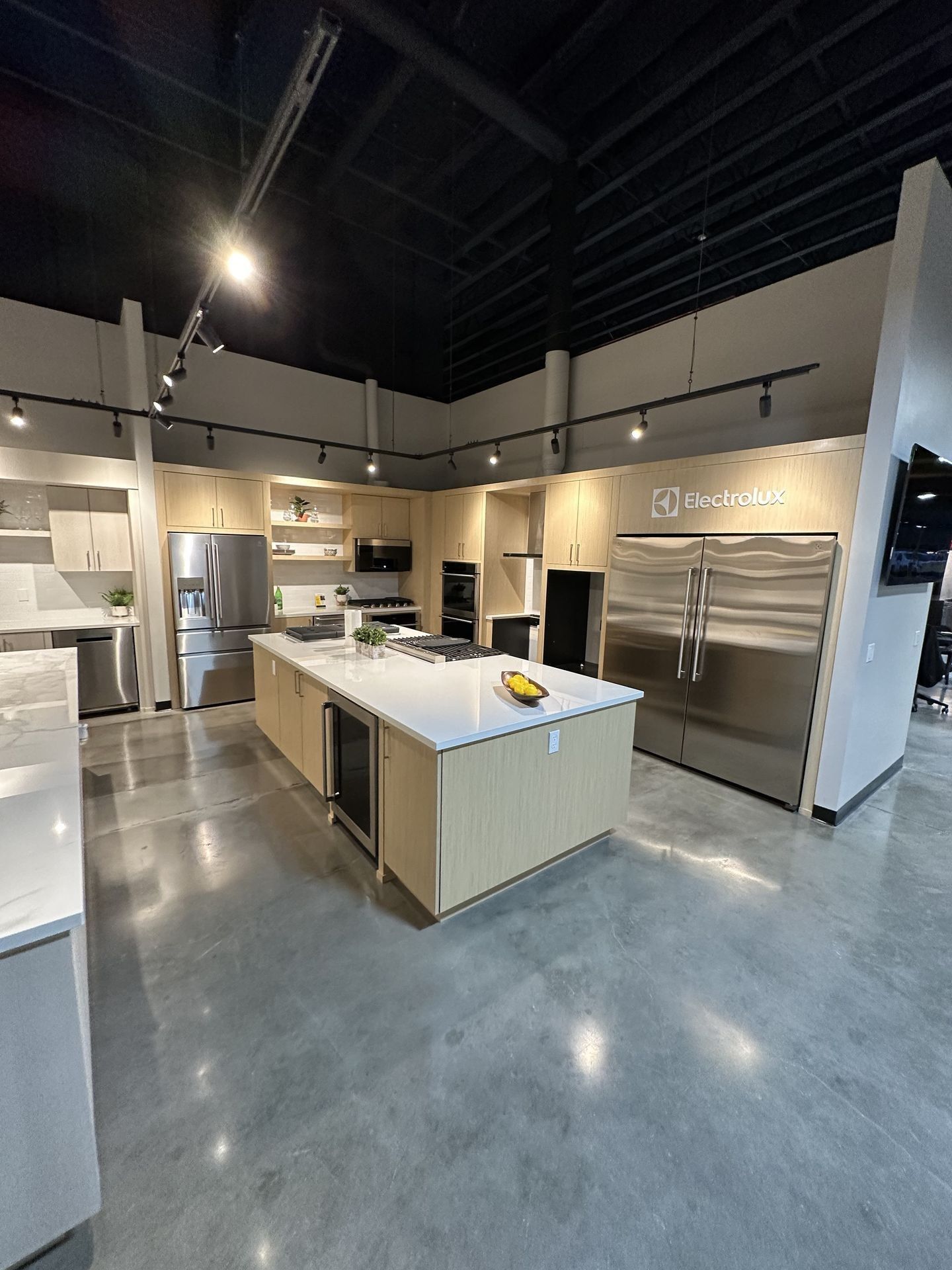 A kitchen with stainless steel appliances and a large island in the middle.