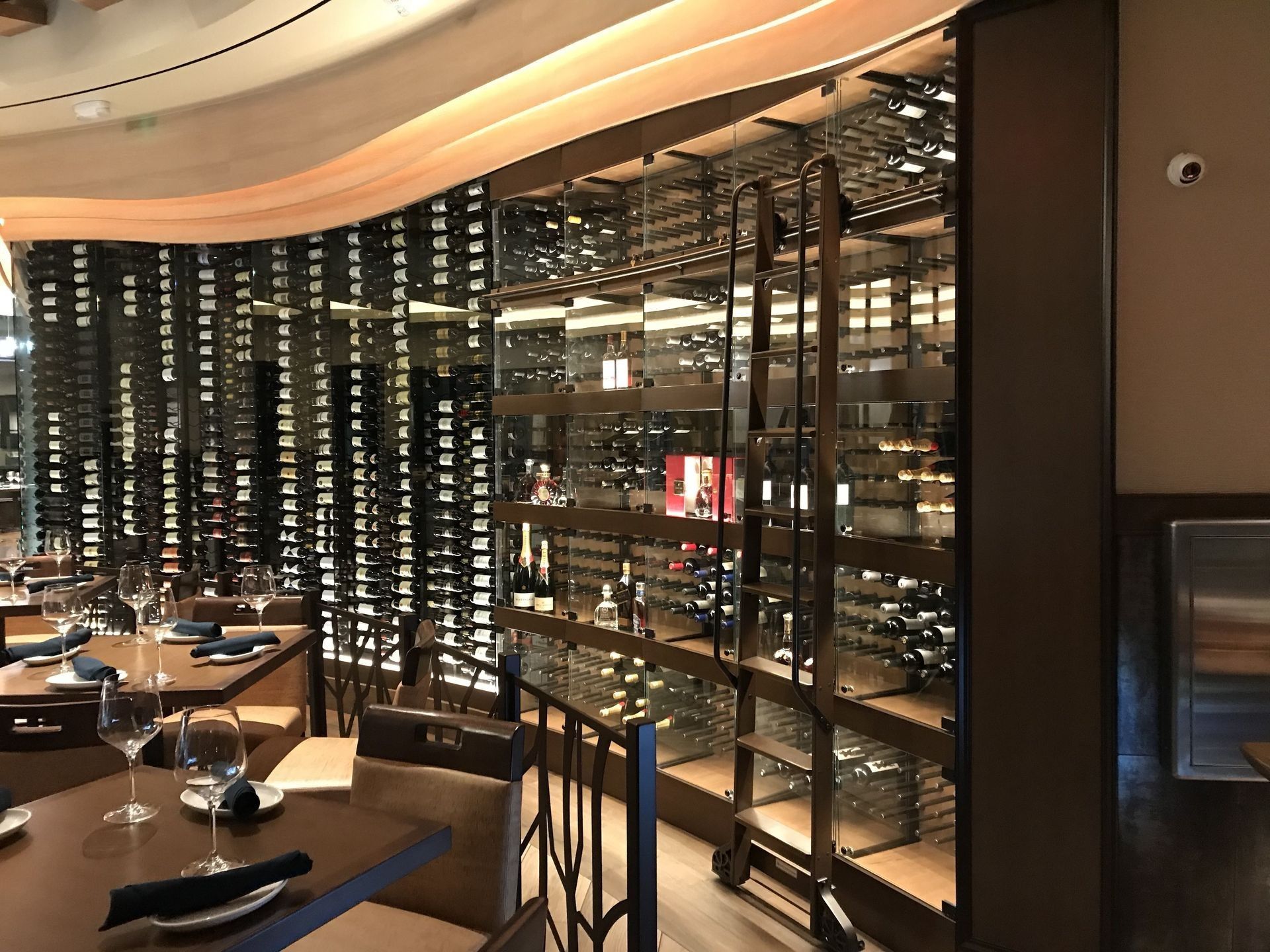 A restaurant with a lot of wine bottles on the wall