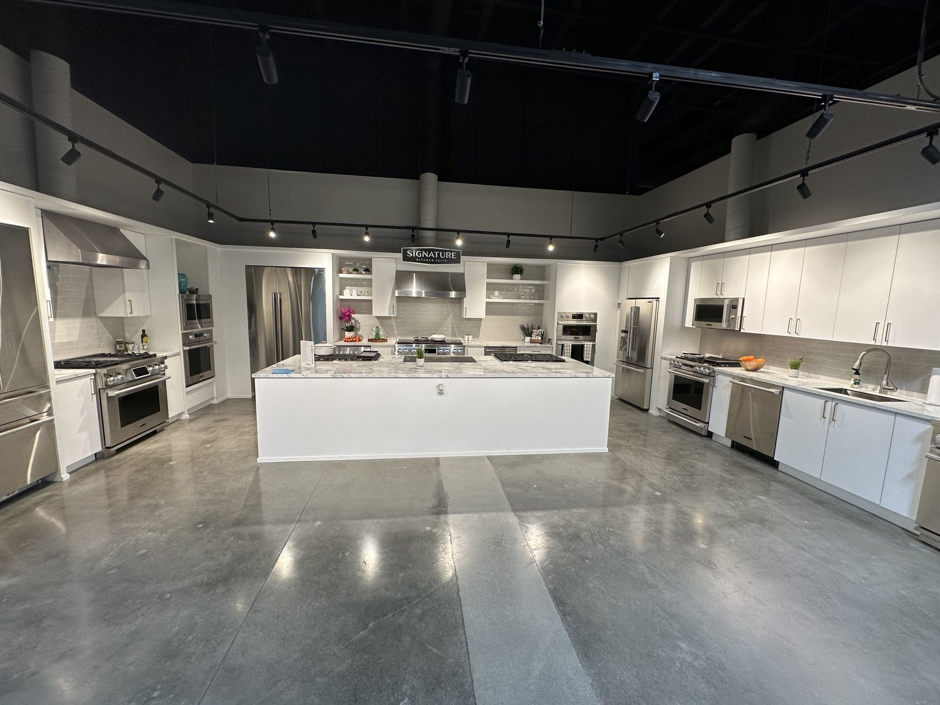 A large kitchen with white cabinets and stainless steel appliances.