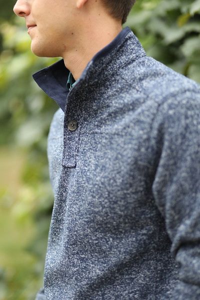 A close up of a man wearing a blue sweater and a blue shirt.