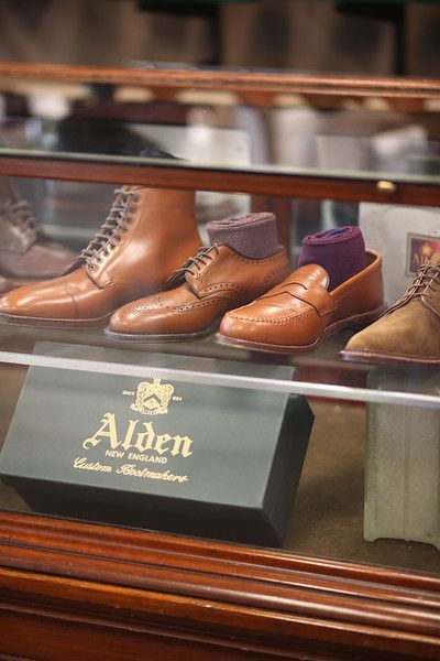 A display case filled with a variety of brown shoes and socks.