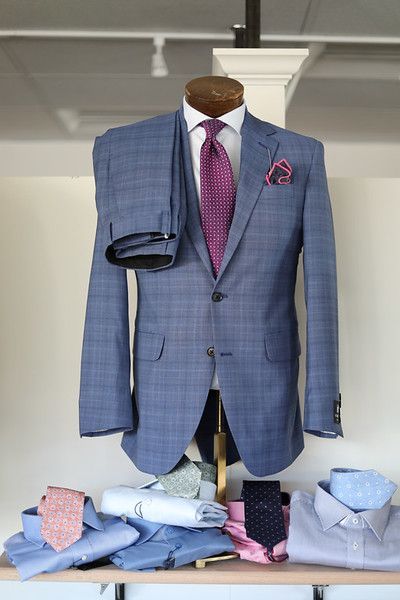A mannequin wearing a blue suit and purple tie