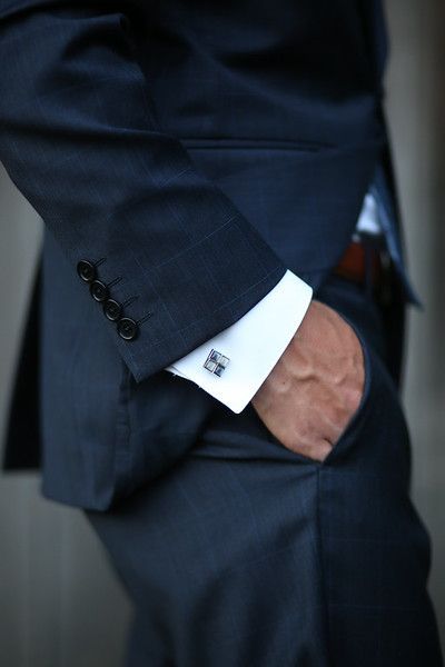 A man in a suit has his hand in his pocket