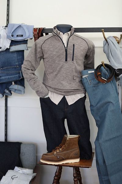 A mannequin is wearing a grey sweater and brown boots