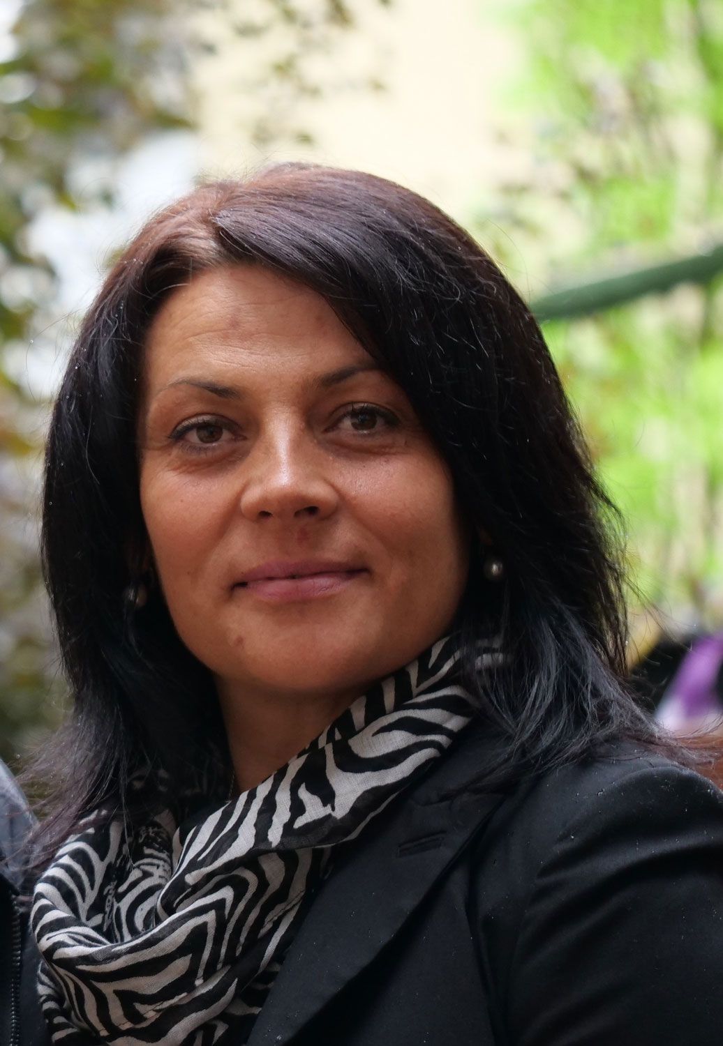 Eine Frau mit schwarzer Jacke und Schal mit Zebramuster