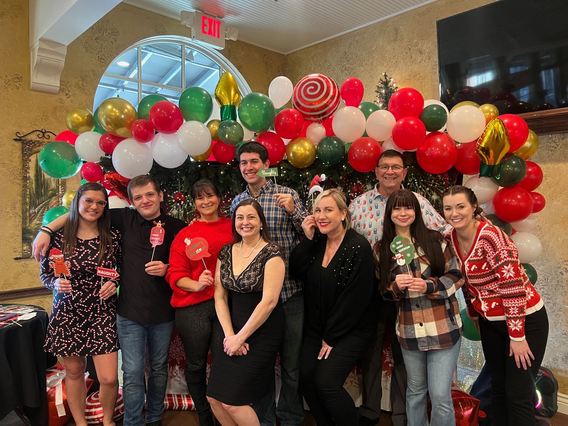 A group of people are posing for a picture in front of a christmas decoration.