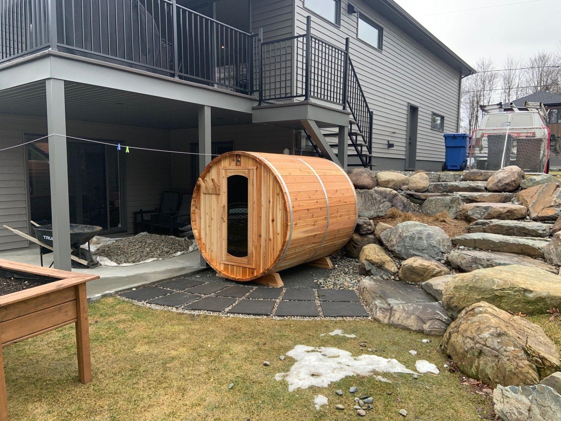 Un tonneau en bois se trouve dans l'arrière-cour d'une maison.