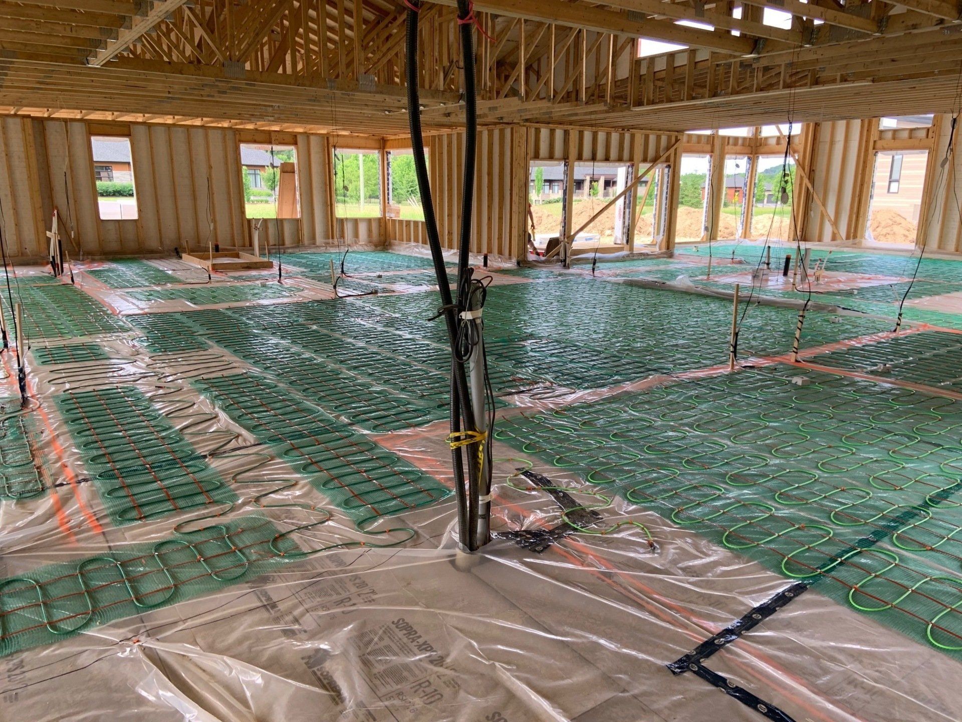 Une grande pièce en construction avec beaucoup de plastique vert sur le sol.