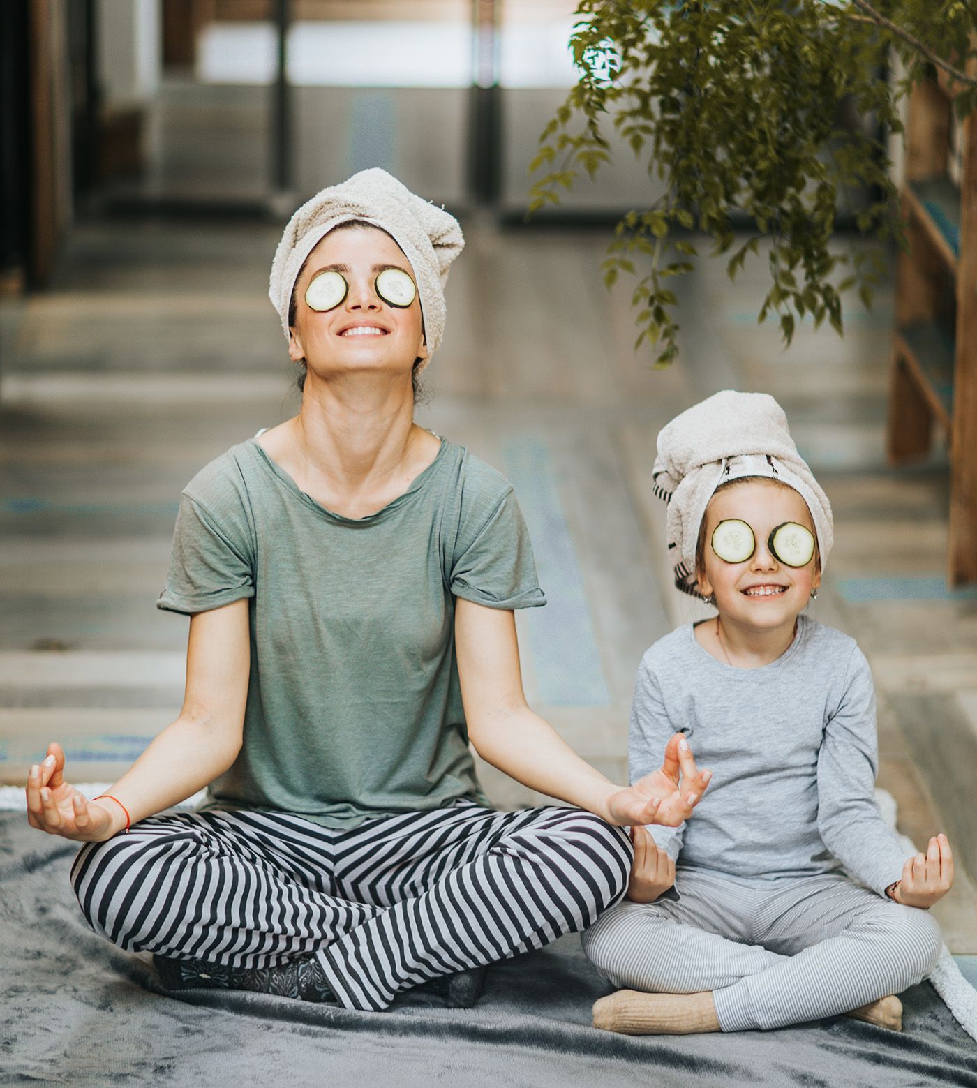 Une femme et un enfant sont assis en position du lotus sur une couverture.