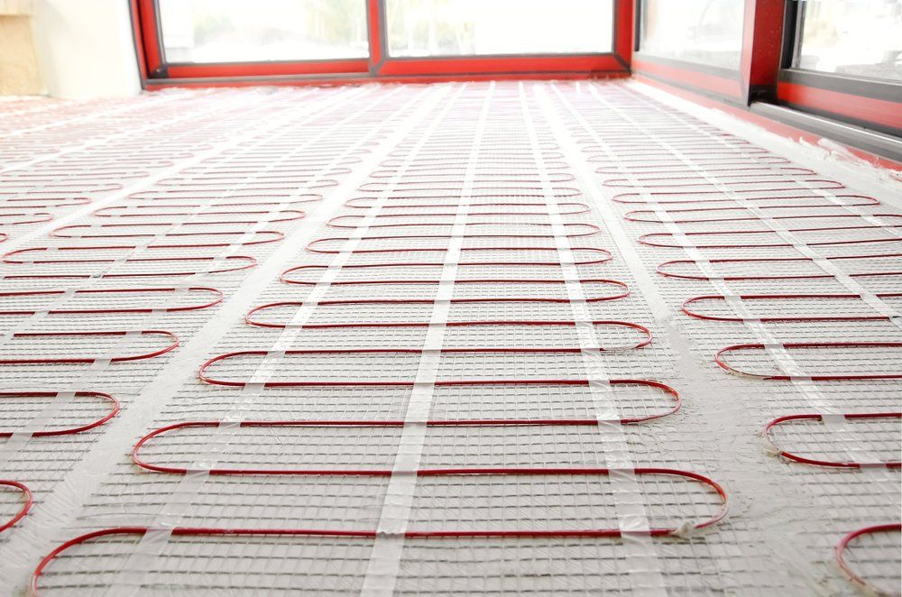 Un gros plan d'un plancher chauffant dans une pièce avec une porte coulissante en verre.