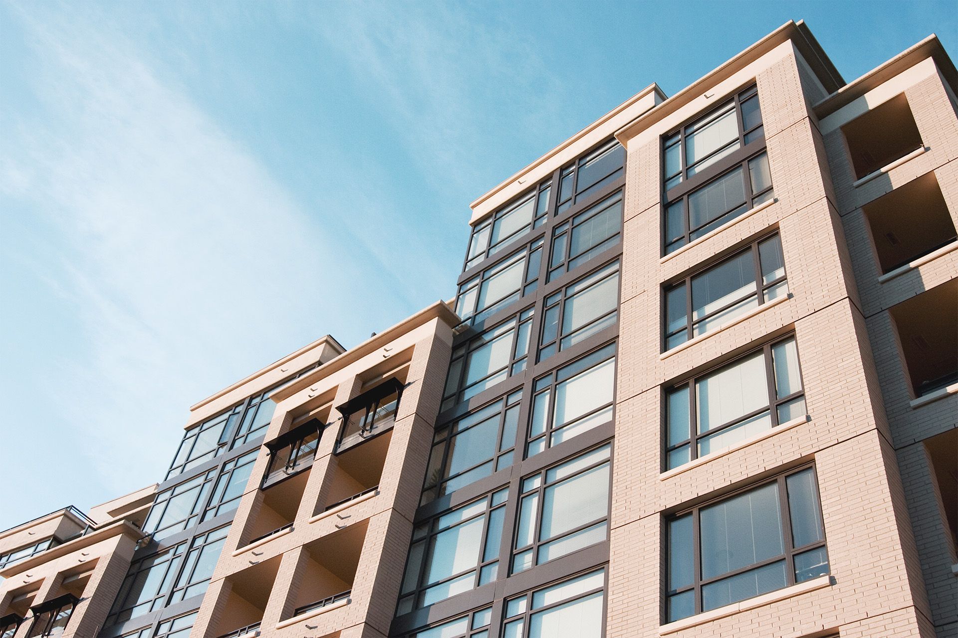 Un grand bâtiment avec beaucoup de fenêtres contre un ciel bleu.