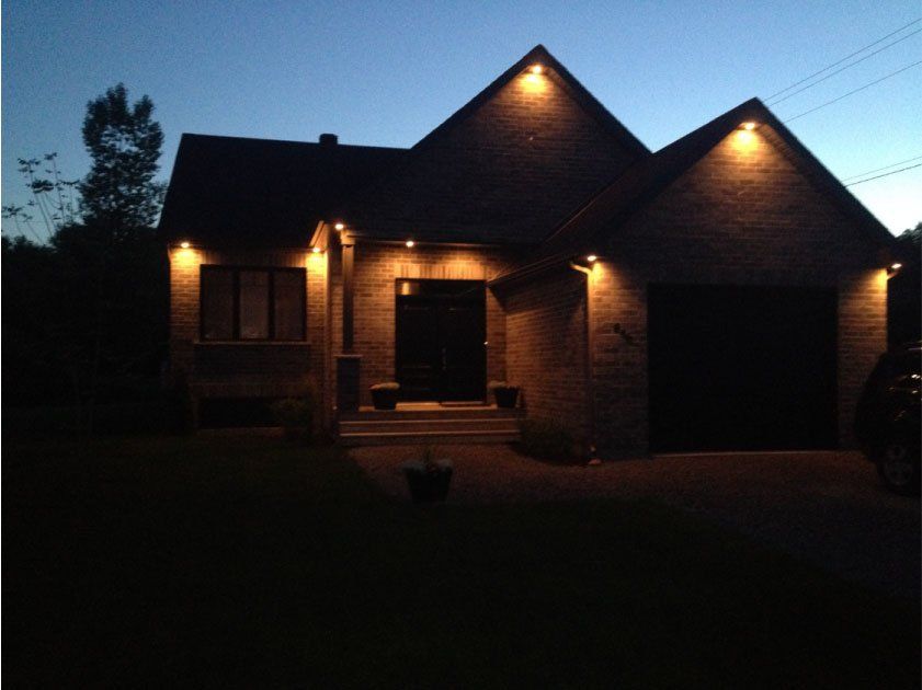 La façade d'une maison est éclairée la nuit