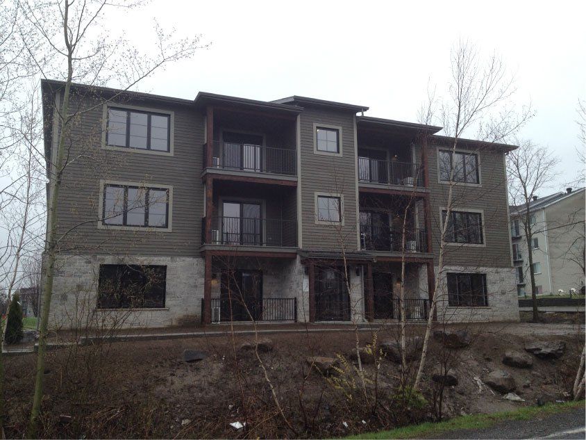 Un grand immeuble d'appartements avec beaucoup de fenêtres et de balcons