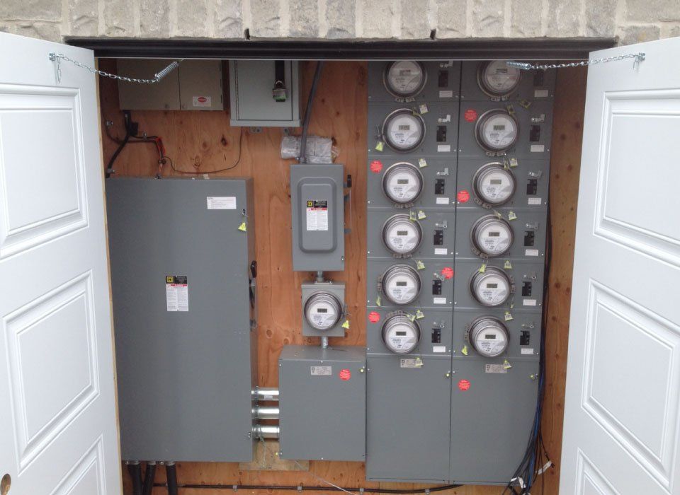 Un grand panneau électrique se trouve à l'intérieur d'un garage avec les portes ouvertes.