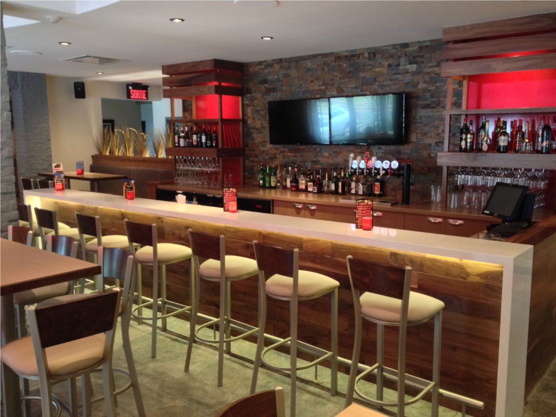 Un restaurant avec un long bar et des tables et des chaises