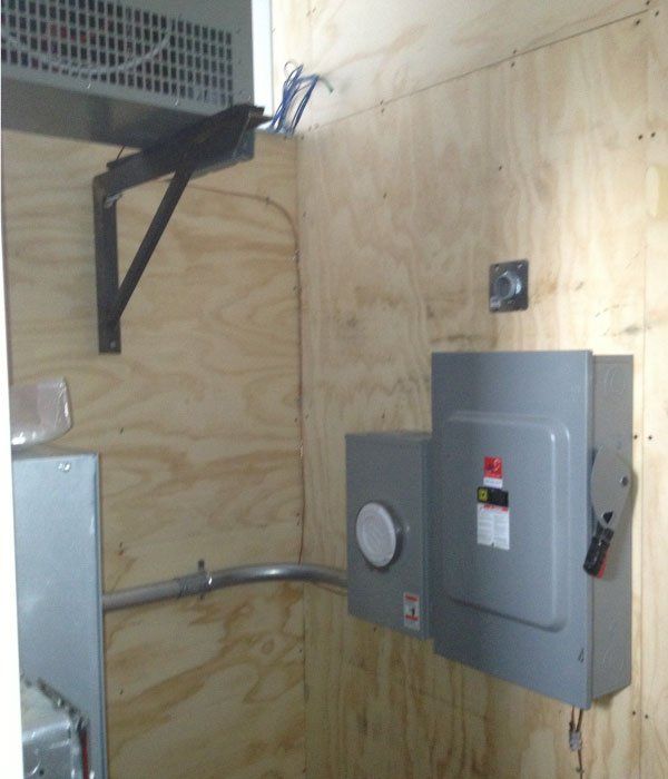 Une pièce avec une boîte grise sur le mur sur laquelle est écrit « électrique »