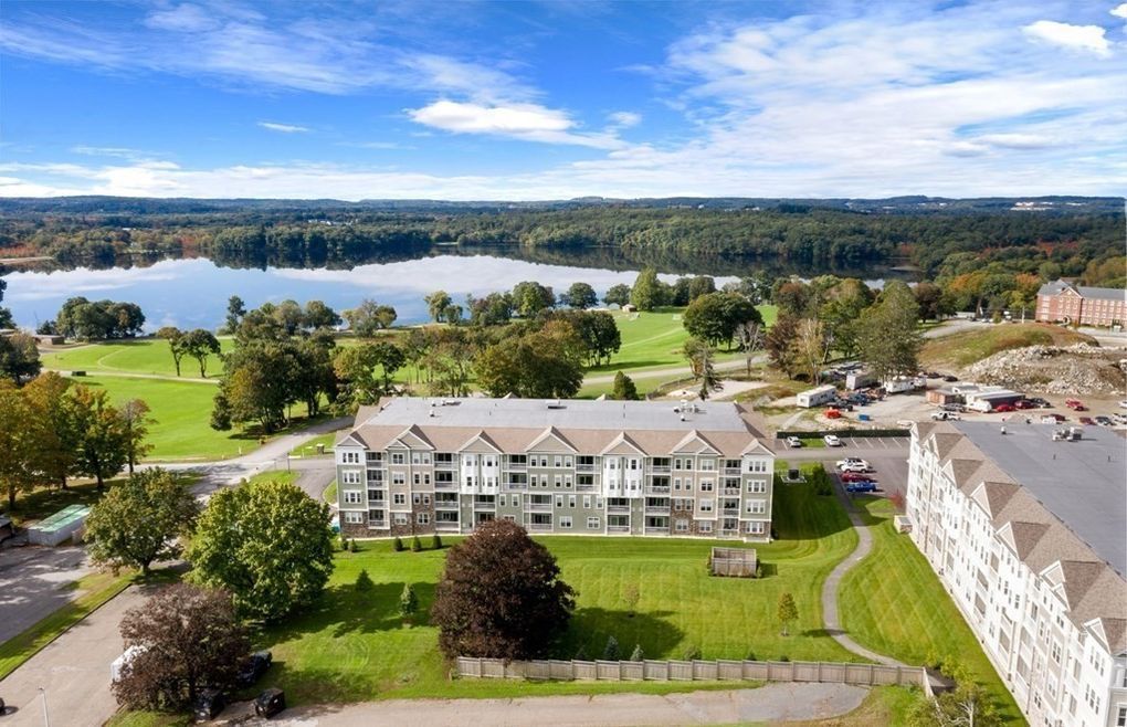 An aerial view of a building with a lake in the background